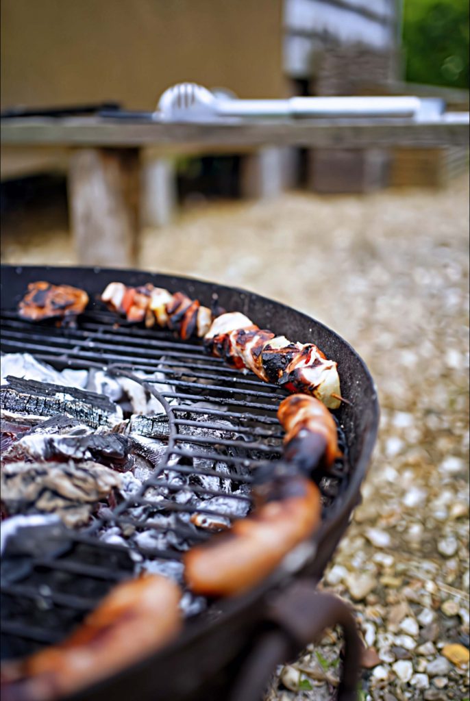 Kebab skewers cooking on a barbecue near one of the Cabins at Loose Reins