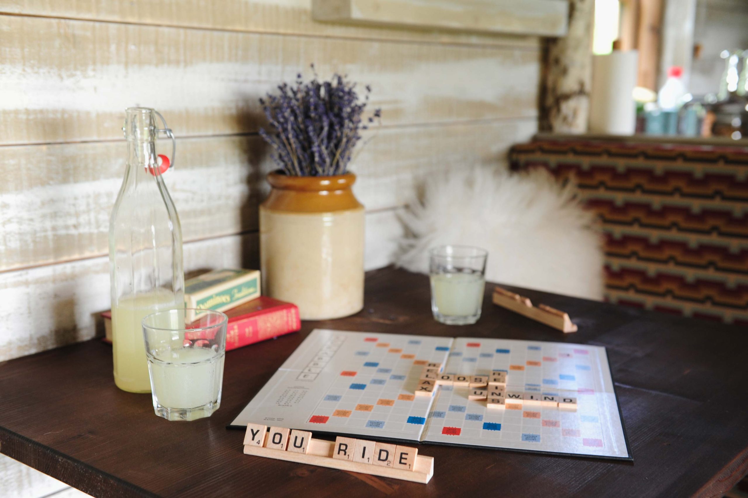 A game of scrabble and two drinks on the table inside the cabin at Loose Reins
