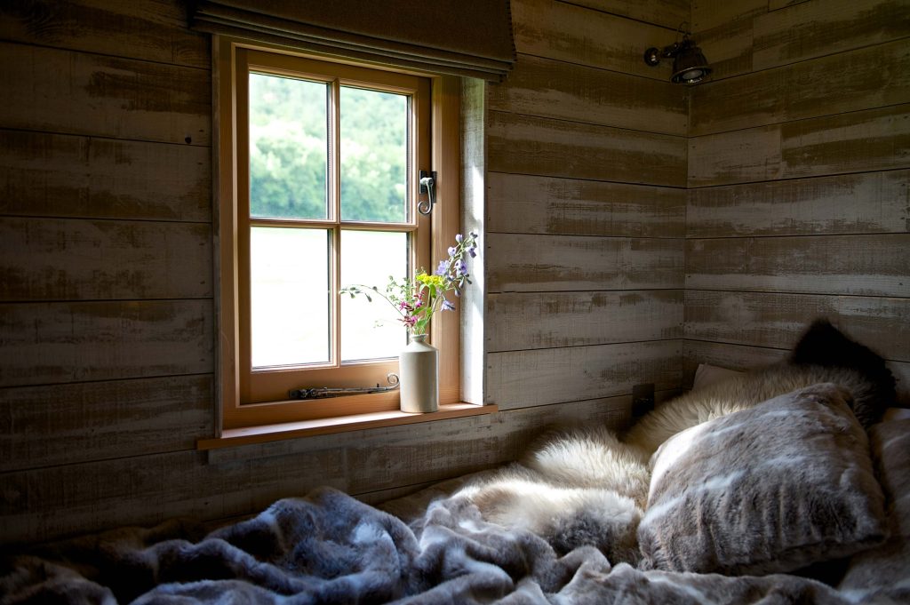Sunlight coming through the window onto the cosy bedding inside one of the Cabins at Loose Reins