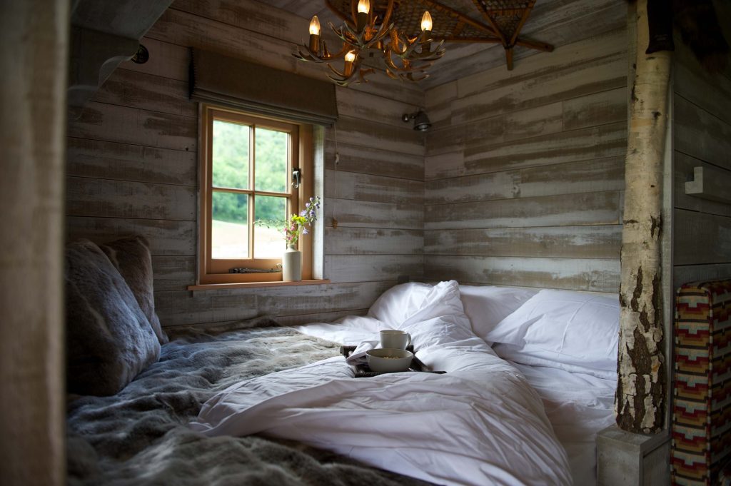 The cosy bed inside the cabin at Loose Reins with a tray of breakfast bowls and cosy blankets