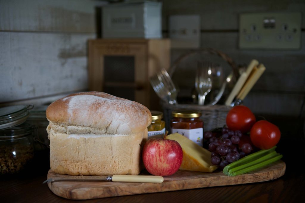 Fresh bread with apples cheese and chutney on the kitchen side in one of the Cabins at Loose Reins