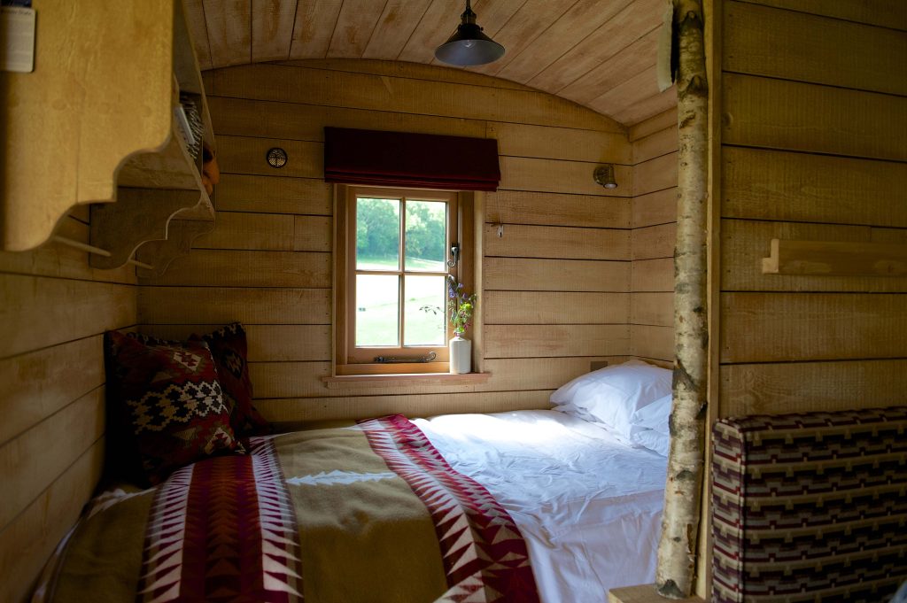 The bed with cosy blanket inside one of the Cabins at Loose Reins