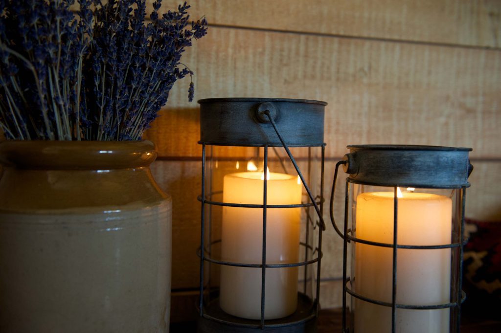 Cosy lit candles and lavender on the table inside a cabin at Loose Reins