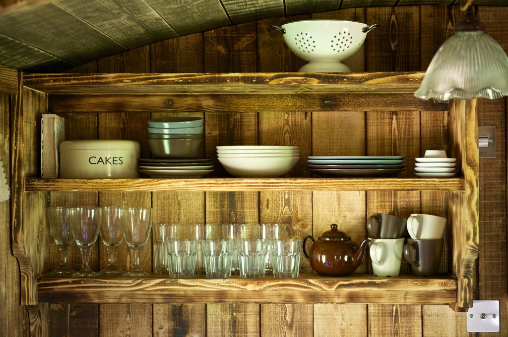 Crockery storage shelves inside the kitchen in one of the Cabins at Loose Reins
