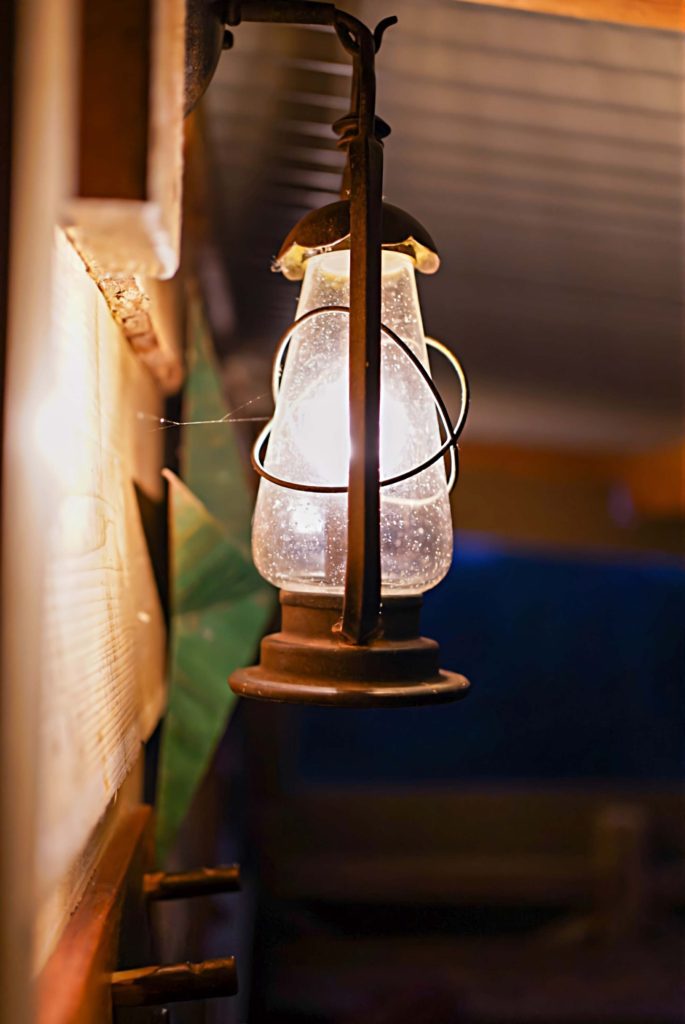 A lantern hanging in the Porch of one of Loose Reins' cabins at night time