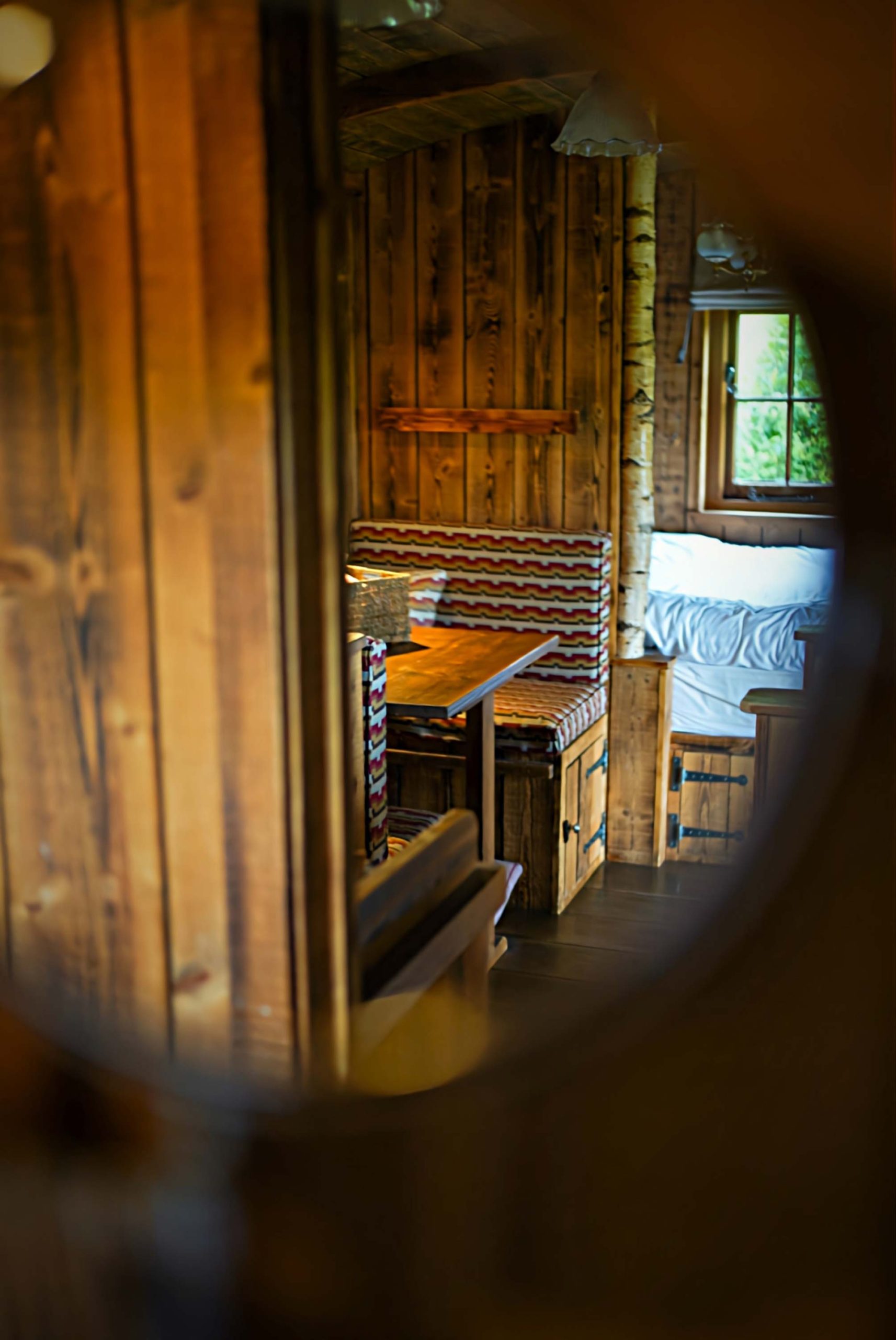 The seating area and bedroom of one of Loose Reins' cabins reflected in a mirror