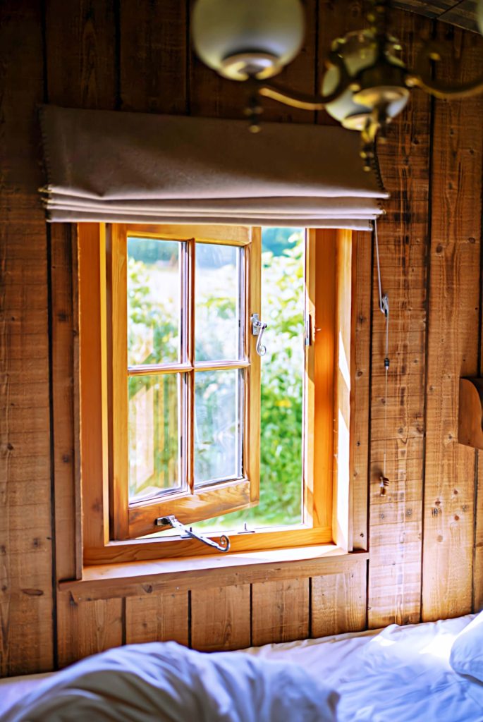 An open window in the bedroom of one of the Cabins at Loose Reins