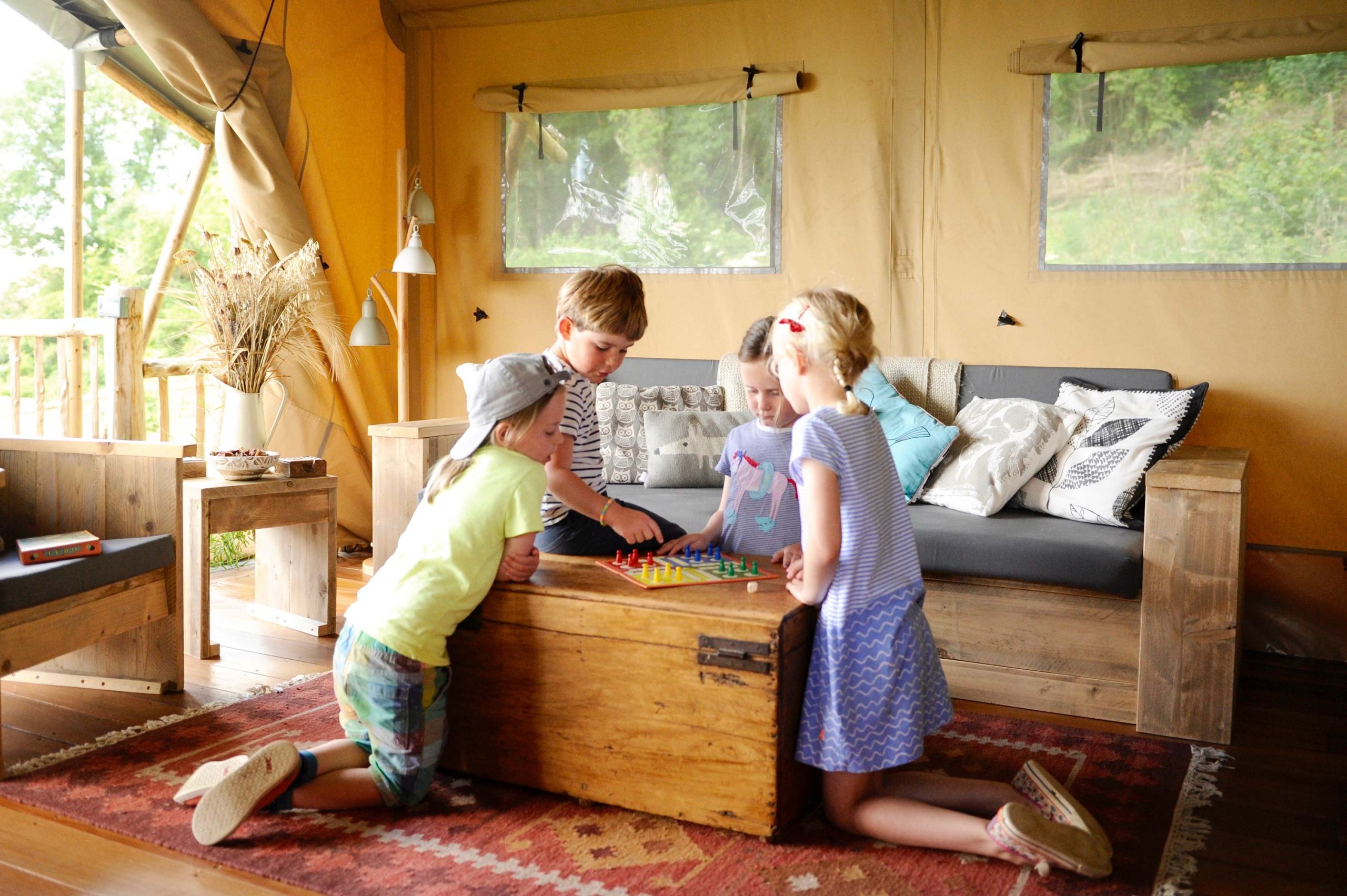 Children playing a board game in the lounge area of one of the Lodges at Loose Reins