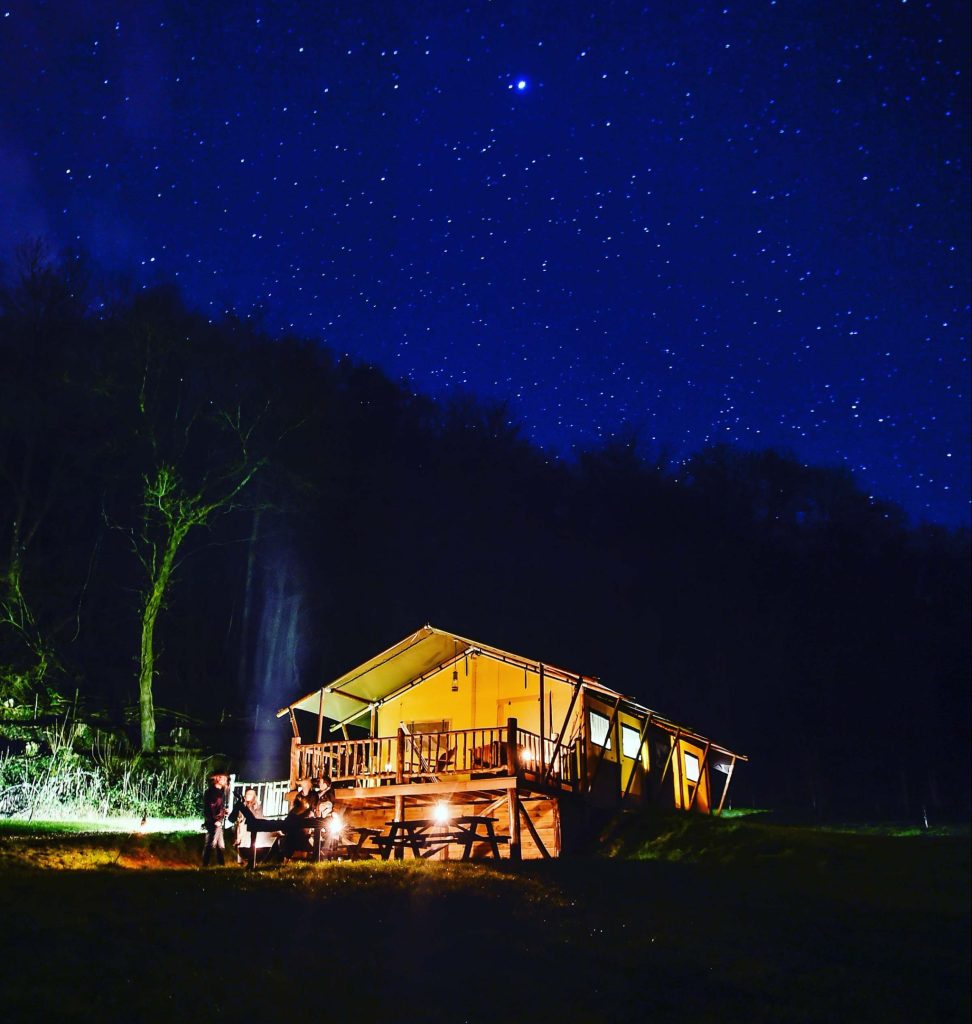 Guests sitting outside their Loose Reins' lodge at night time