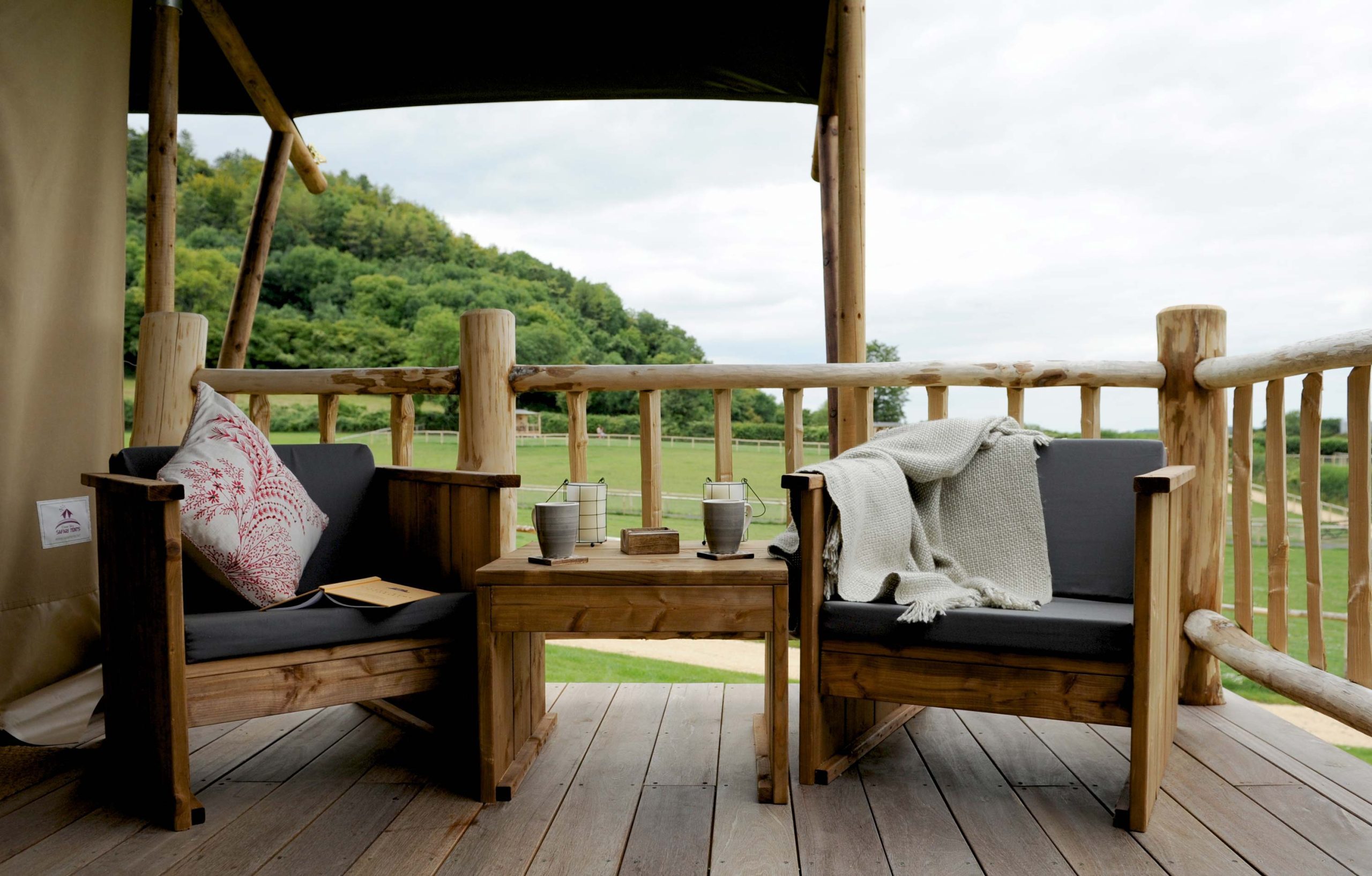 Comfy chairs and cosy blankets on the deck area of a Loose Reins' lodge