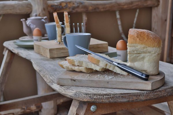 sliced fresh bread and fresh eggs on the deck of a glamping lodge at loose reins in Dorset