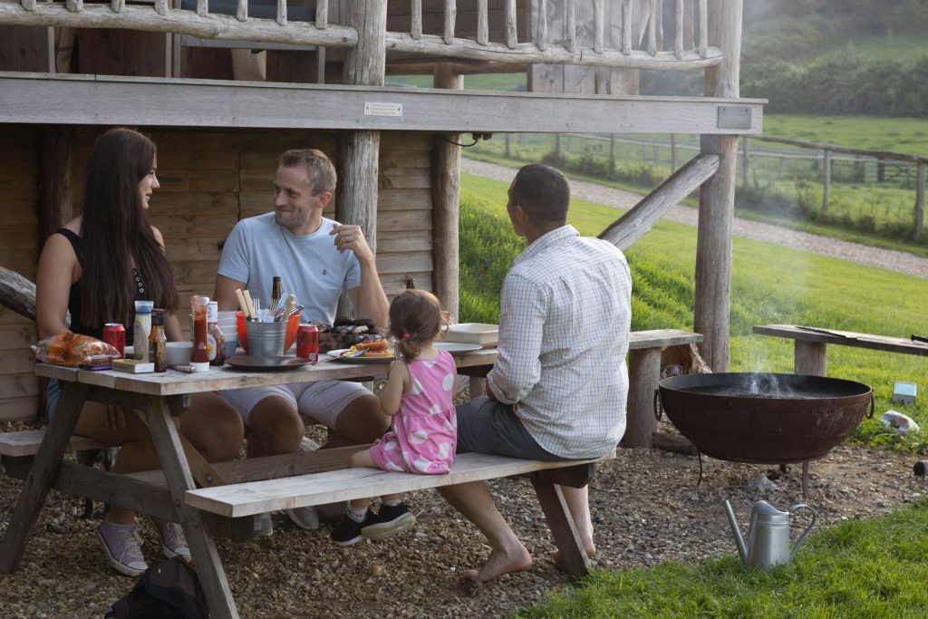 young family dining al fresco at Foresters Glamping Lodge at Loose Reins in Dorset