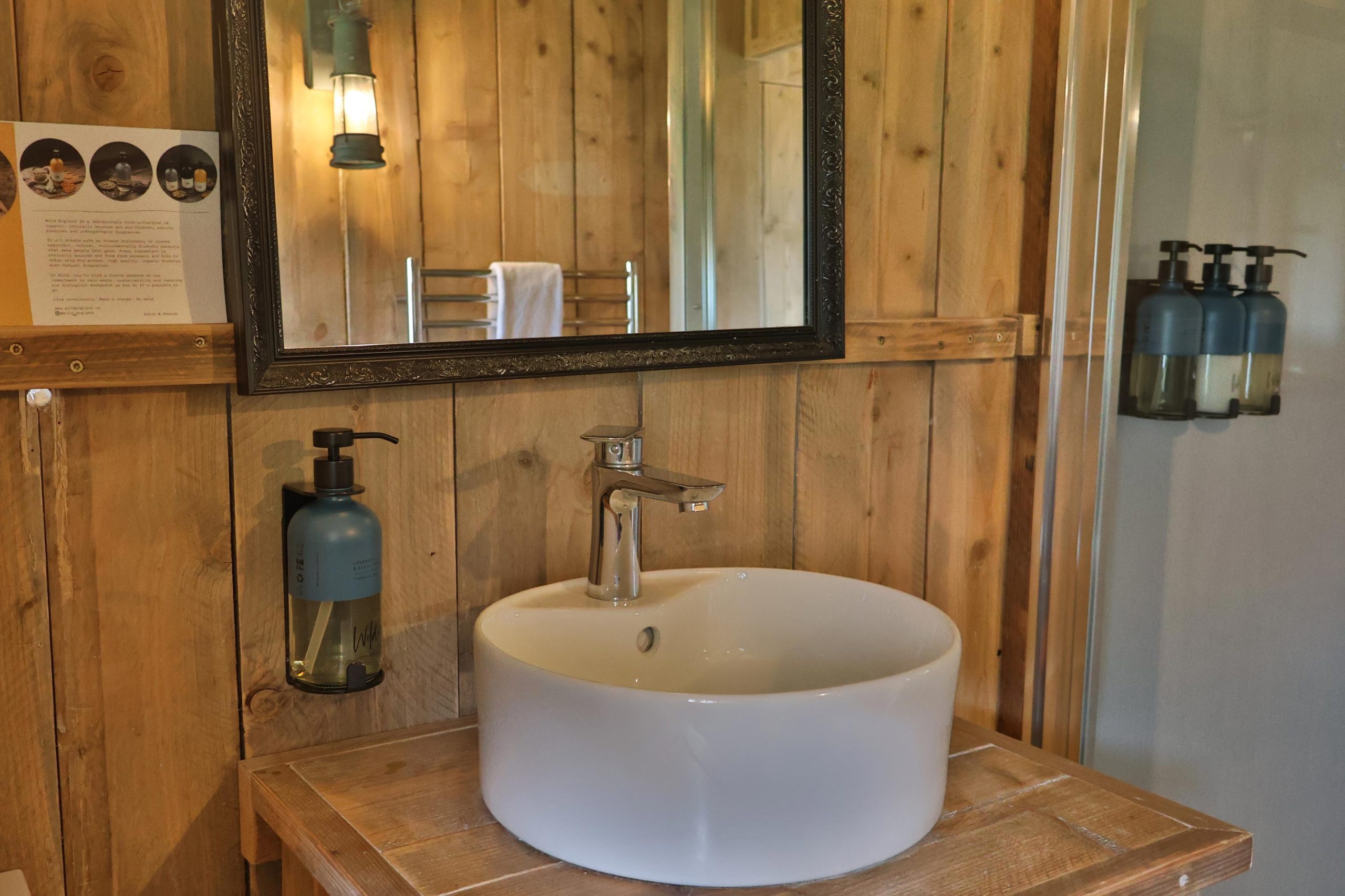 Luxurious wash basin and mirror in wood cladded holiday cabin.