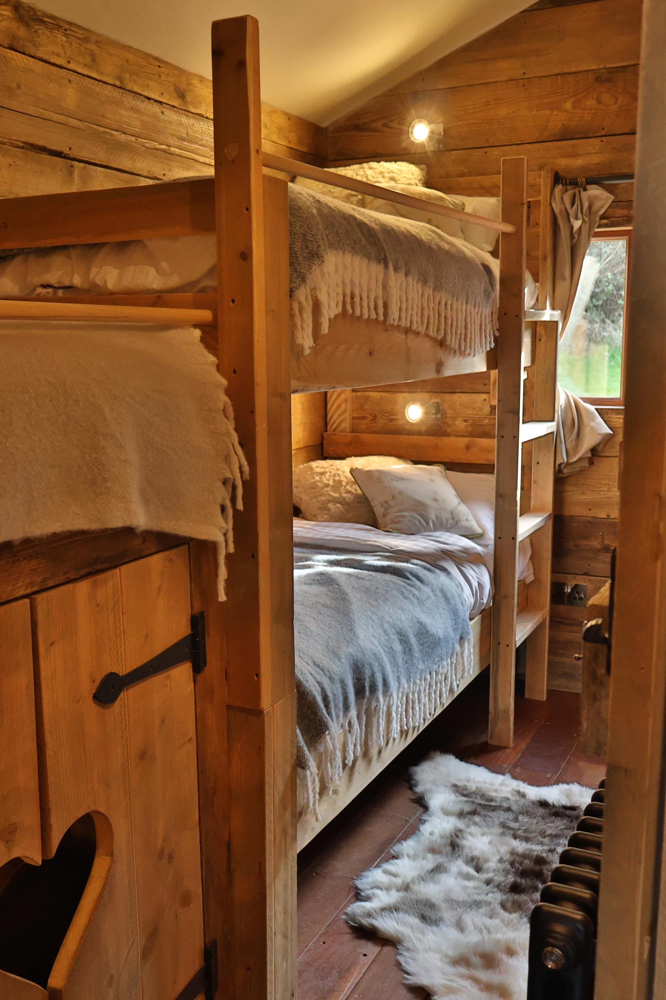 Beautiful wooden carved bunk beds in children's room of family holiday cabin.