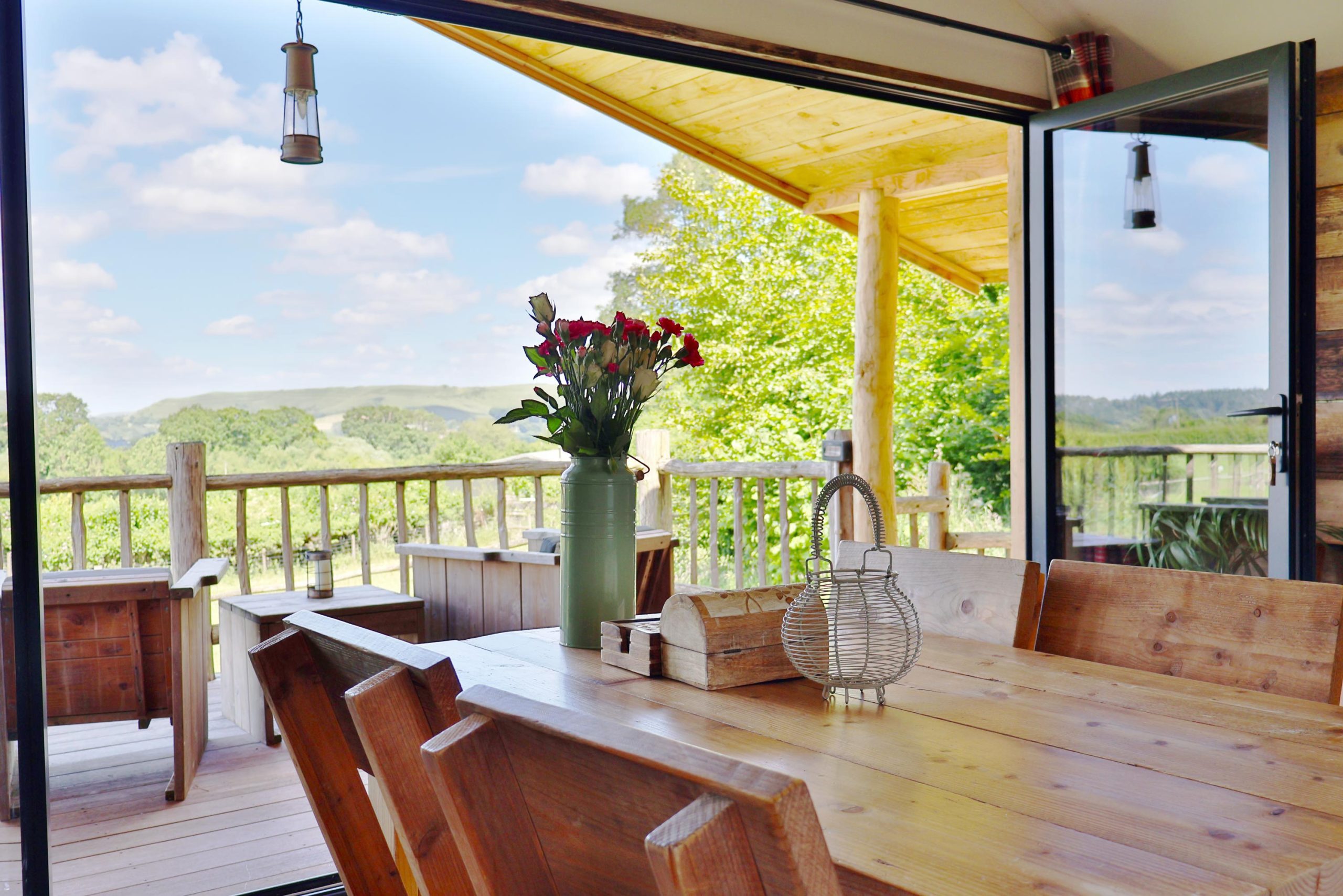 View of North Dorset countryside on a sunny day taken from the Dining table of Foresters Lodge with bifold doors open