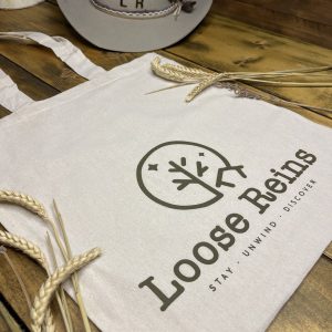 A Tote bag with the Loose Reins logo printed on the front