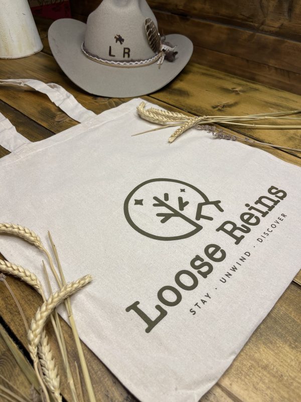 A Tote bag with the Loose Reins logo printed on the front